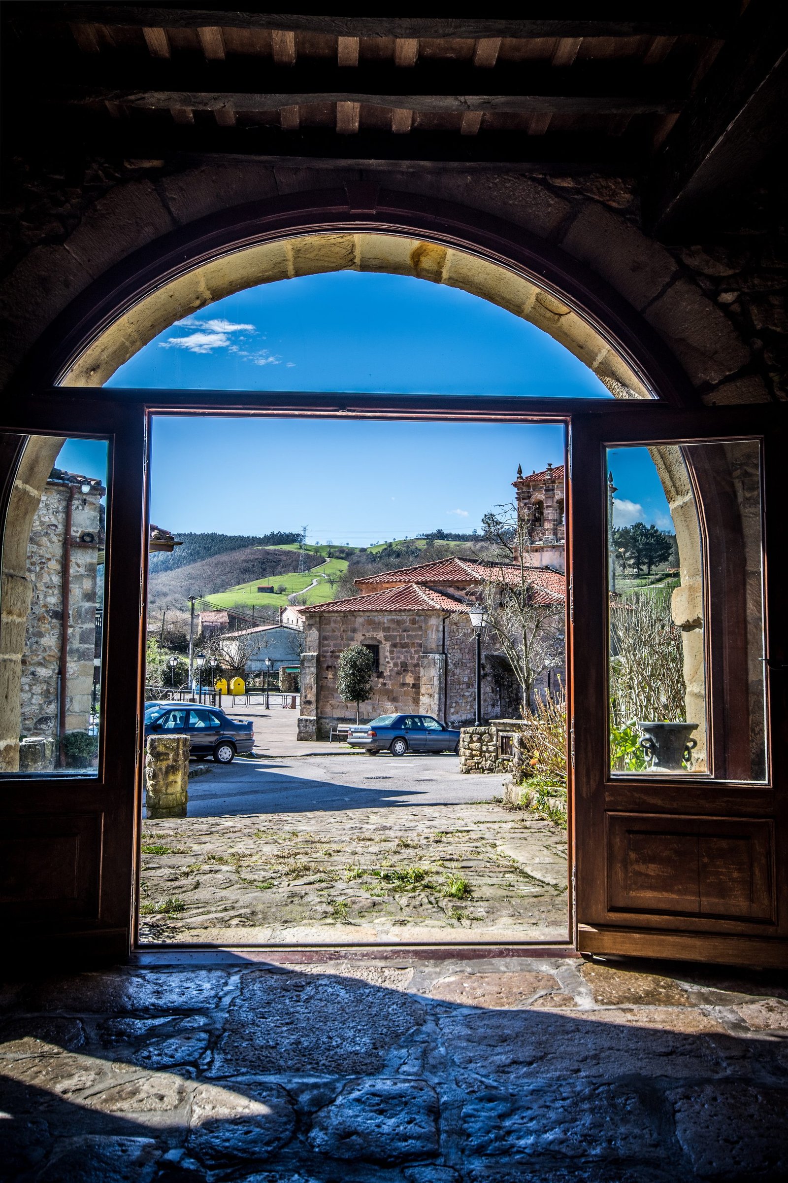 Arco de piedra centenario con luz natural filtrándose en el interior de Finca Gándara